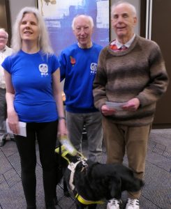 Abi Baker (left, with guide dog Joyce) and John Fullwood (right) receive joint second prize in the Challengers from Bill Armstrong