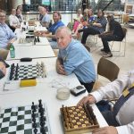 Ready to start play! The Parliamentary Chess Club team is on the left and the BCA players are facing them.