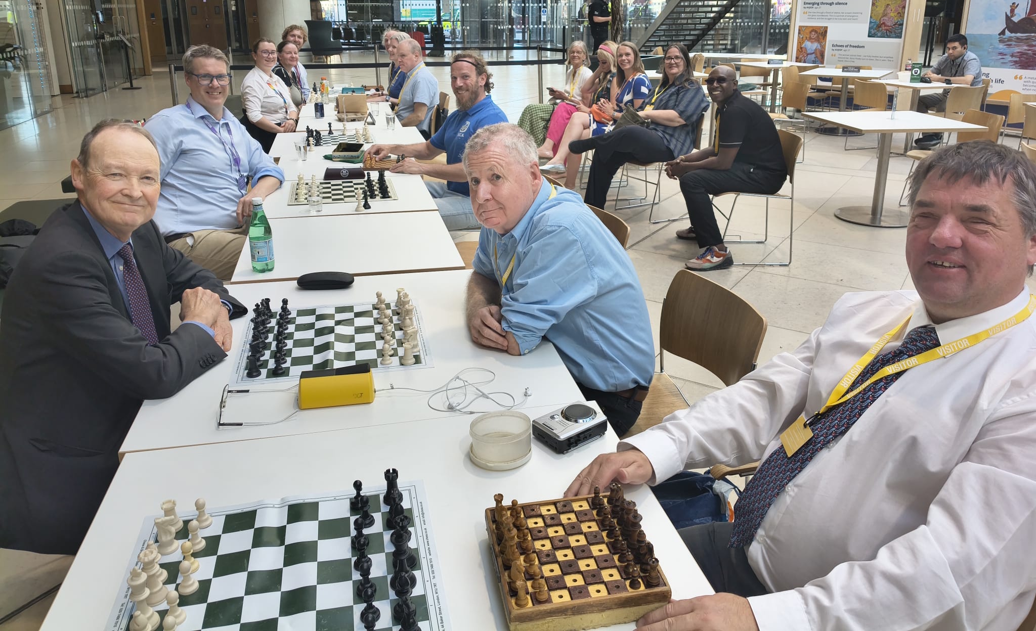 Ready to start play! The Parliamentary Chess Club team is on the left and the BCA players are facing them.