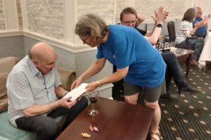 Stan Lovell receives a braille card from Gill Smith.